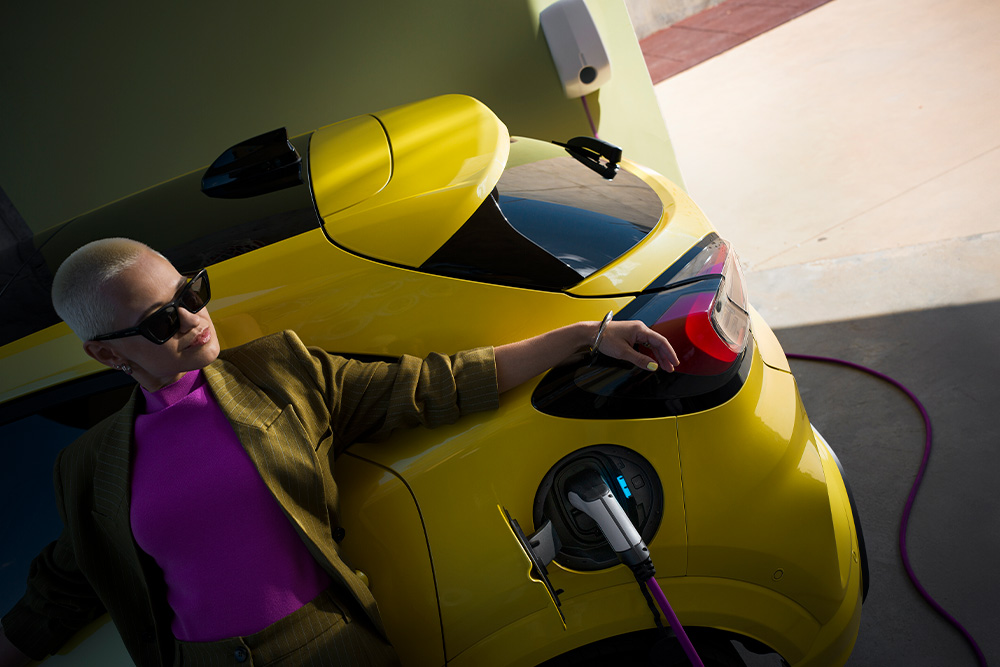 Uma pessoa carregando um carro elétrico Ford Capri amarelo.