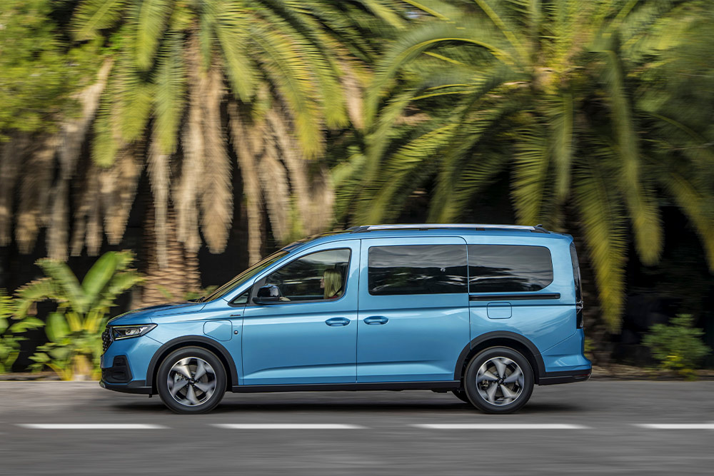 Uma carrinha híbrida plug-in Ford Tourneo Connect azul estacionada numa rua.