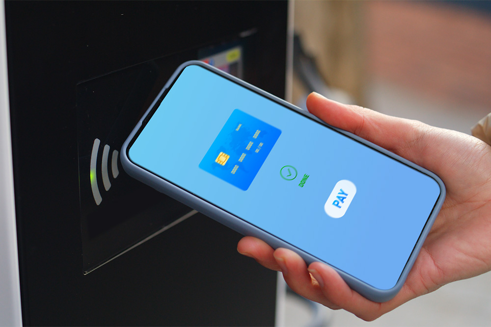 Um smartphone a ser utilizado num ponto de carregamento público de VE para pagamento sem contacto.