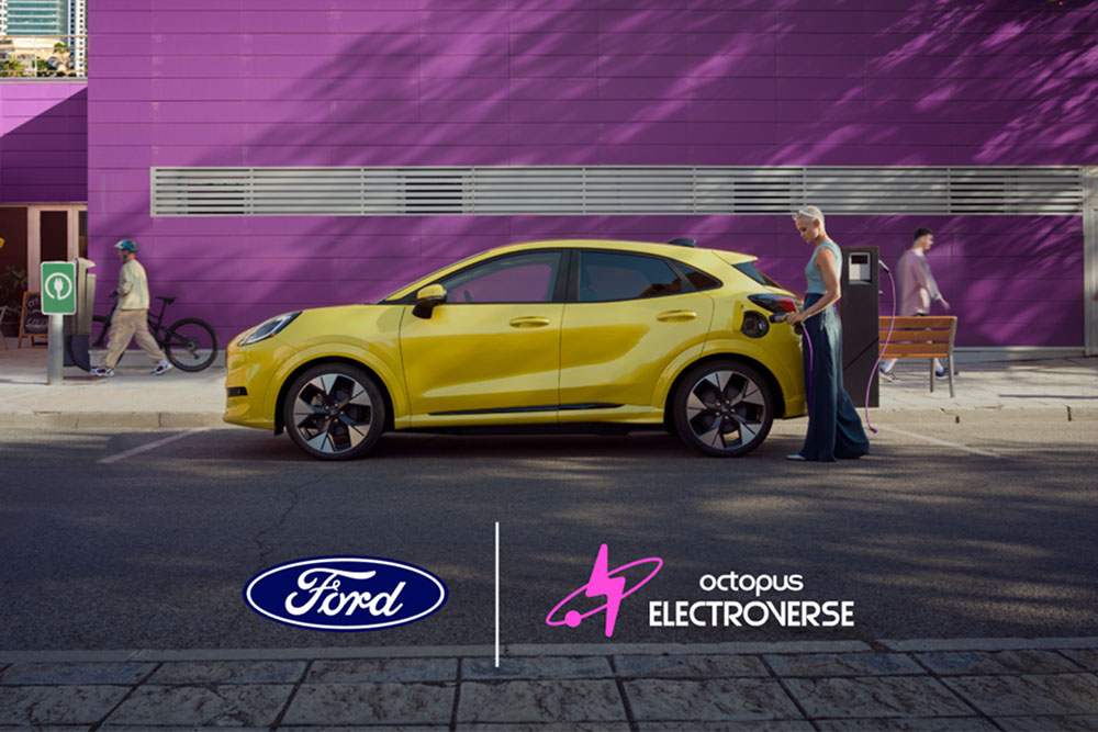 Vista lateral de um Ford Puma Gen-E elétrico amarelo ligado a um ponto de carregamento público.