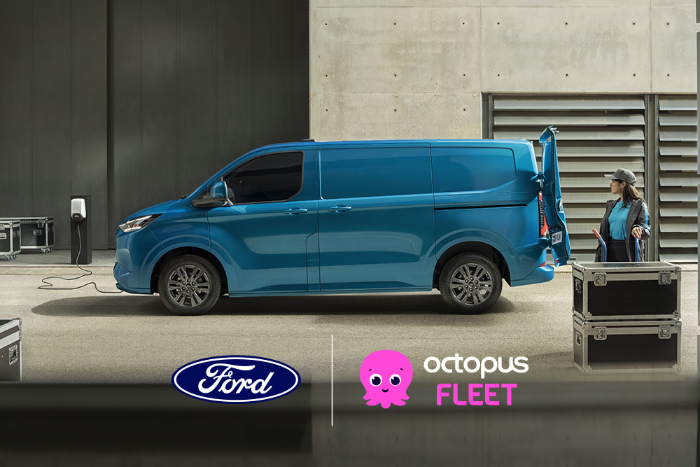 Vista lateral de um Ford E-Transit Custom azul estacionado com uma porta traseira aberta e uma pessoa parada por perto.