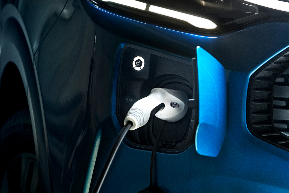 Grande plano de um cabo de carregamento elétrico ligado a um furgão elétrico Ford E-Transit Custom.