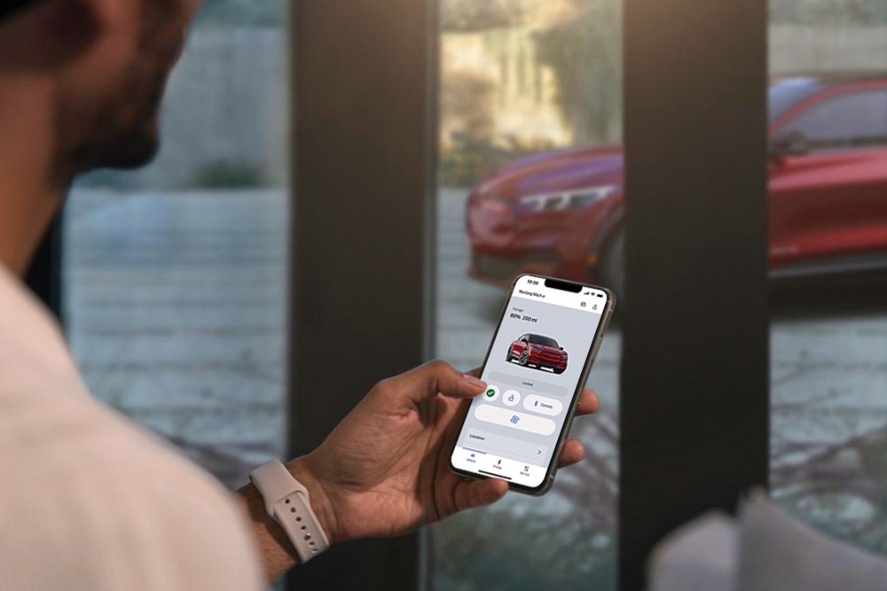 Um homem a ver as definições do seu novo Ford Mustang Mach-E utilizando as funcionalidades do controlo remoto do veículo na aplicação FordPass