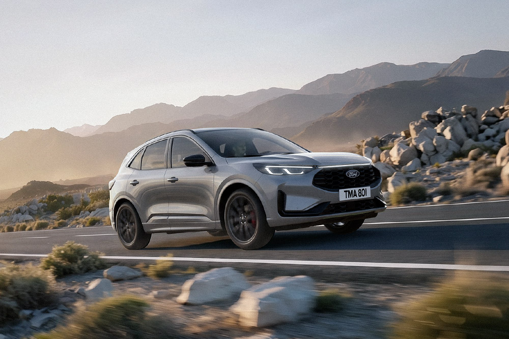 Um Ford Kuga prateado numa paisagem montanhosa e rochosa.