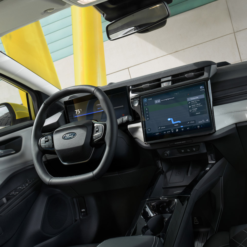 Vista interior de um Ford Puma, com um plano aproximado do volante e do ecrã tátil.