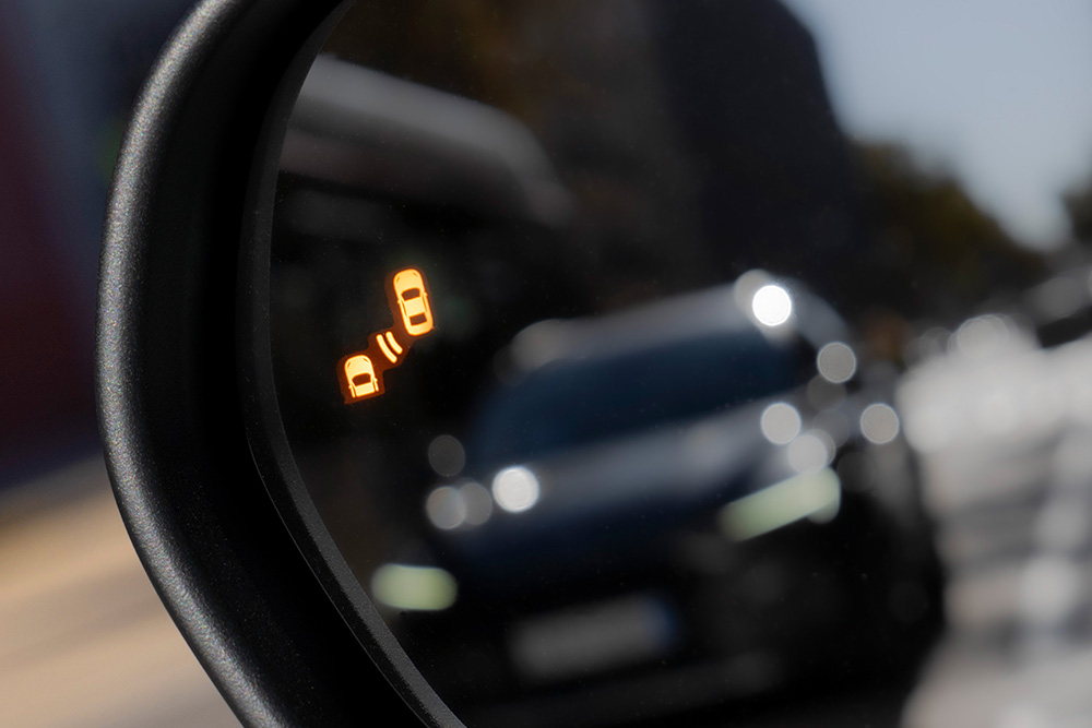 Grande plano do alerta do Sistema de Deteção do Ângulo Morto no espelho retrovisor lateral do Ford Puma Gen-E®.