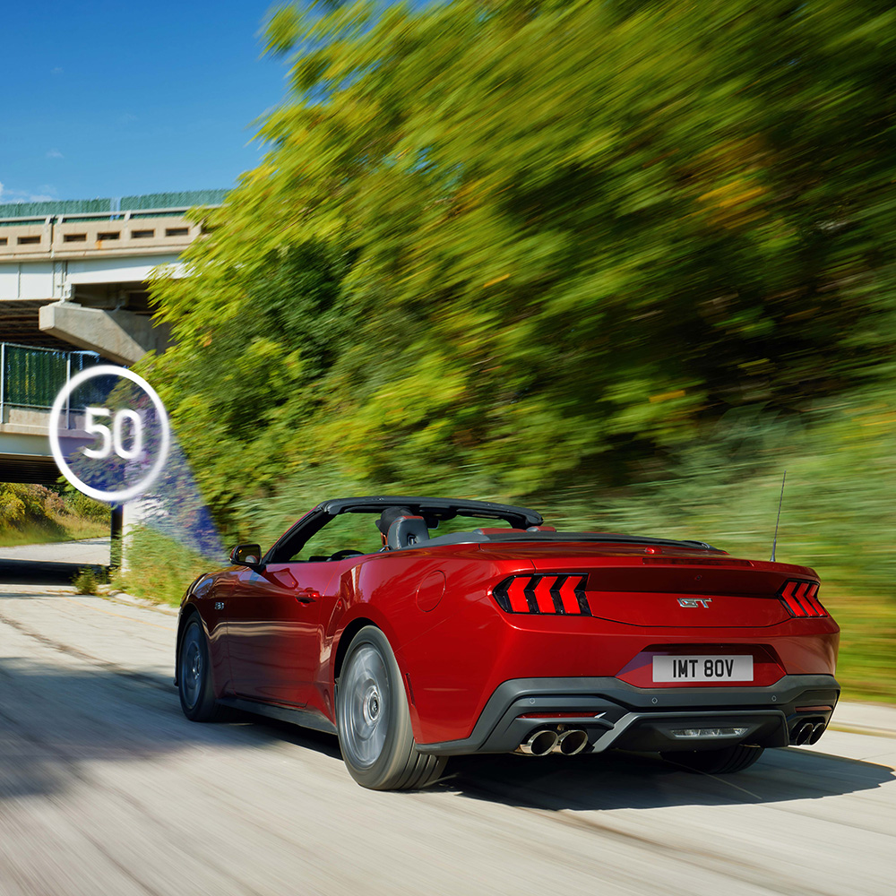 Ford Mustang vermelho a percorrer uma estrada depois de passar por um sinal de trânsito
