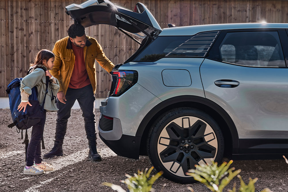 Pai e filha a carregar a bagageira de um Ford Explorer® em prateado.