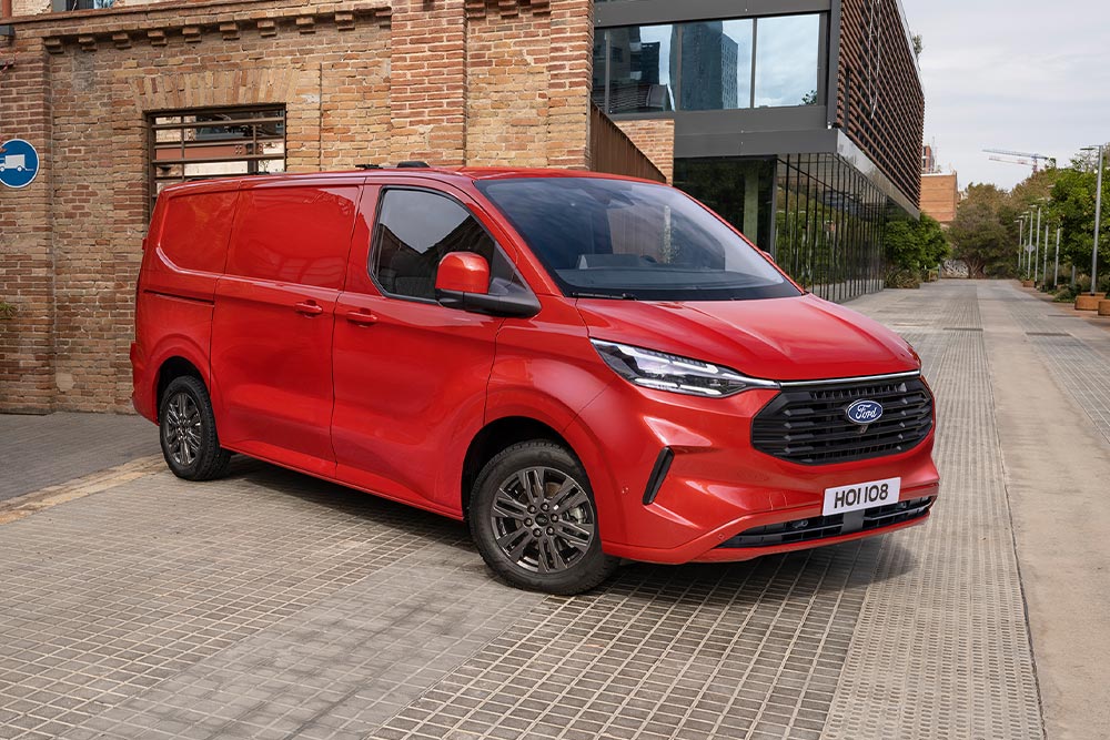 Furgão Ford Transit Custom vermelho estacionado numa rua urbana.