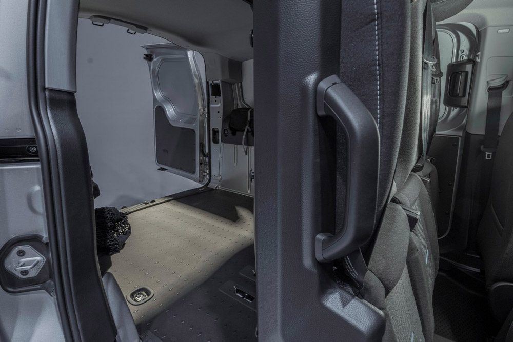 Interior de um Ford Transit Connect FlexCab que mostra os bancos traseiros rebatidos e a área de carga vazia.