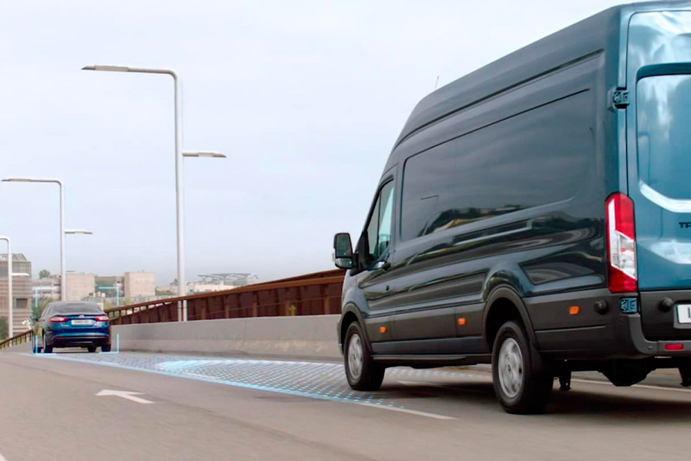 Carrinha Ford Transit azul com linhas azuis na estrada a indicar a utilização dos Sistemas Avançados de Assistência ao Condutor.