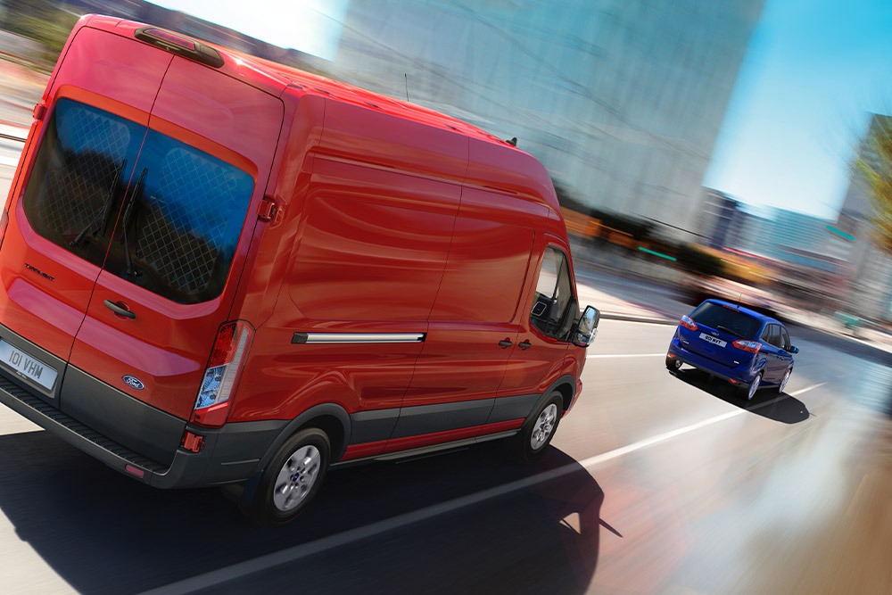 Carrinha Ford Transit vermelha a circular numa estrada.