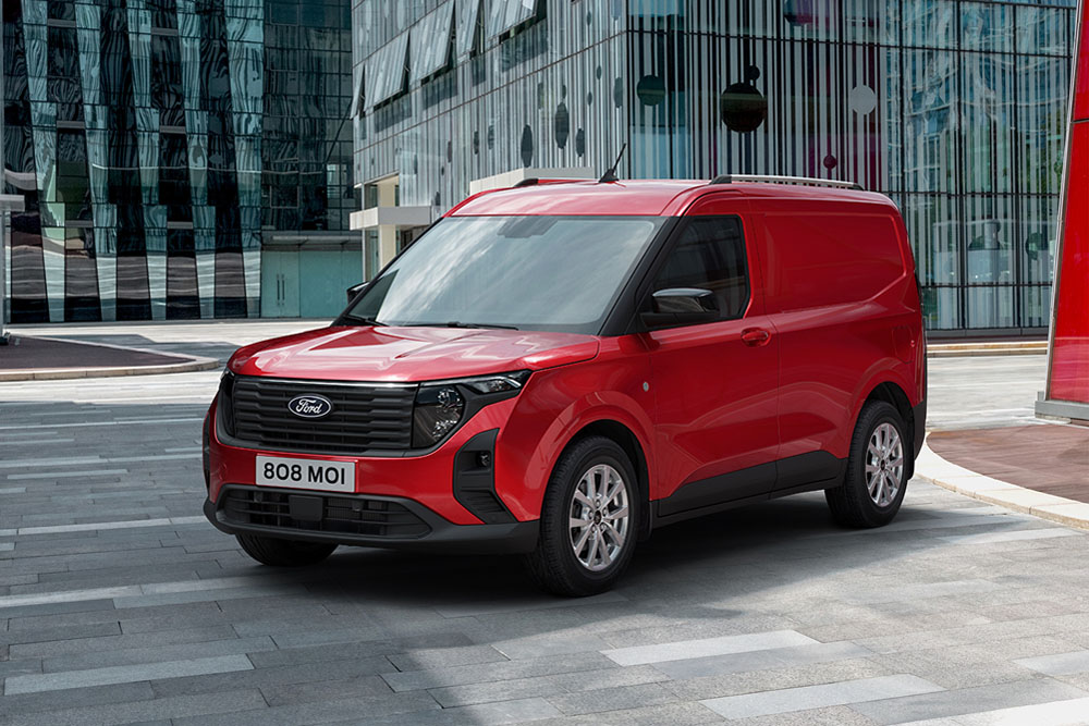 Novo Ford Transit Courier Van vermelho estacionado perto de edifício moderno